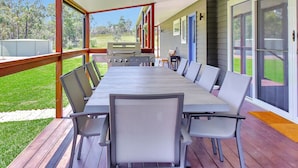 An outdoor covered patio with a long dining table and chairs, a grill, and a view of a grassy yard. - Two for Joy Estate. Sleeping 12, 2 Cottages (North Rothbury)
