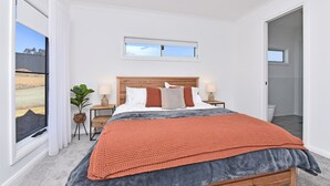 A bedroom with a large bed, a window, a bedside table with a lamp, and a view of the outside. - Two for Joy Estate. Sleeping 12, 2 Cottages (North Rothbury)