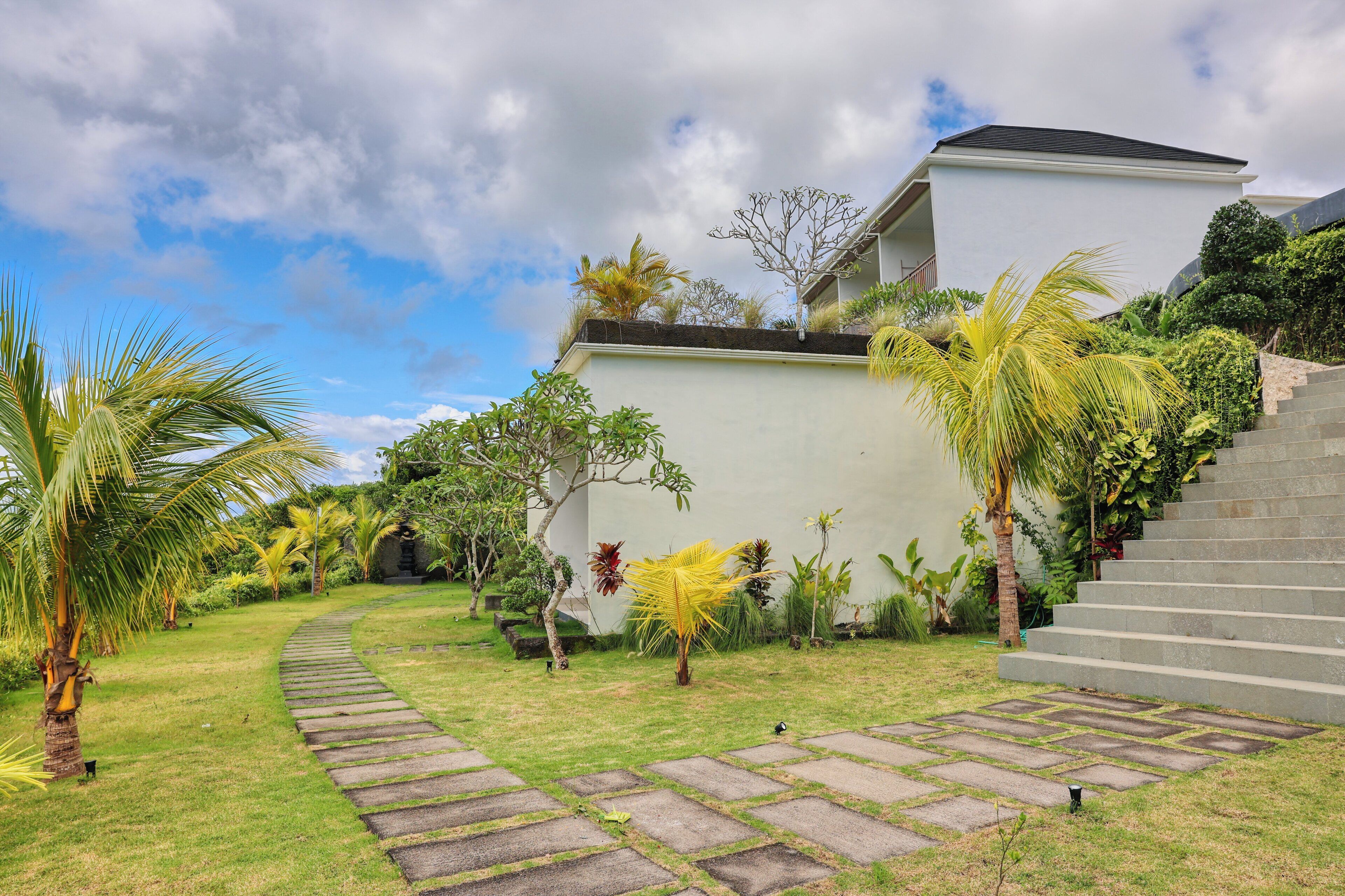 A modern house with a stone pathway leading to a staircase.
