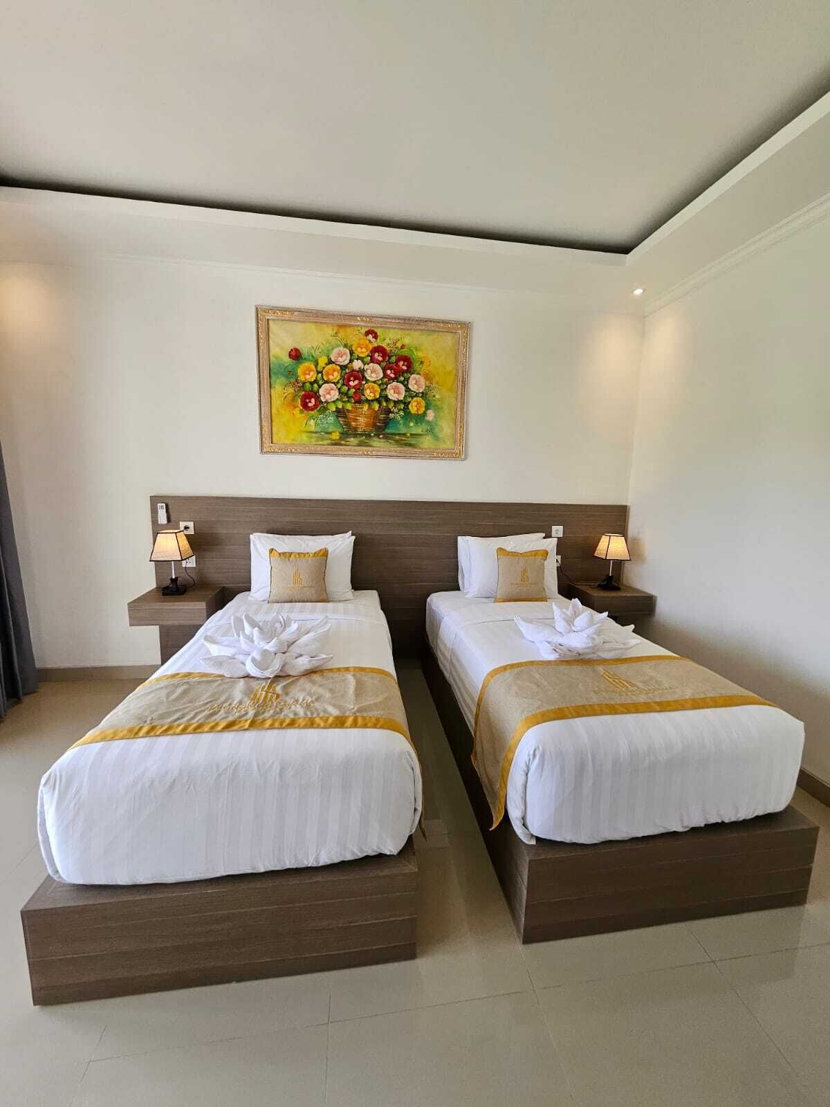 A hotel room with two beds, a painting on the wall, and bedside lamps.