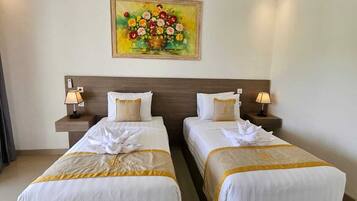 A hotel room with two beds, a painting on the wall, and bedside lamps.
