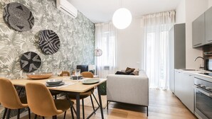 Una cocina moderna con microondas, horno y comedor con mesa y sillas.
