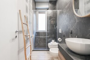 Een douche, een haardroger, een bidet, handdoeken