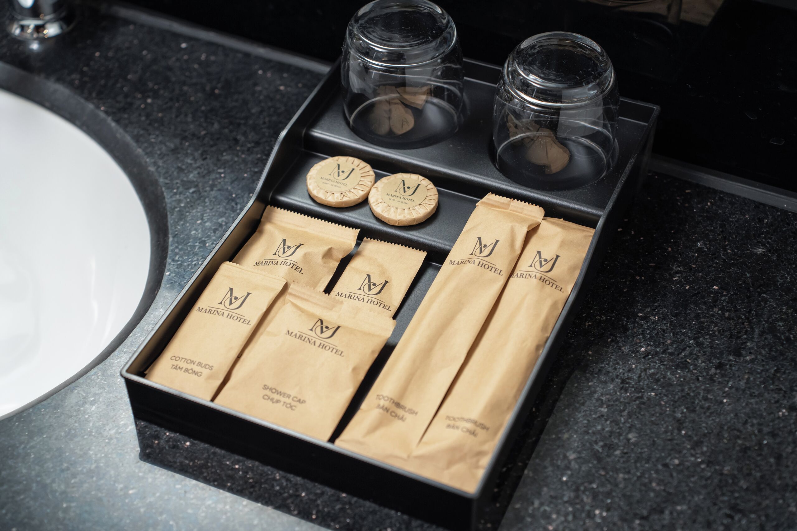 A bathroom tray with toiletries including cotton buds, shower cap, and toothpaste.