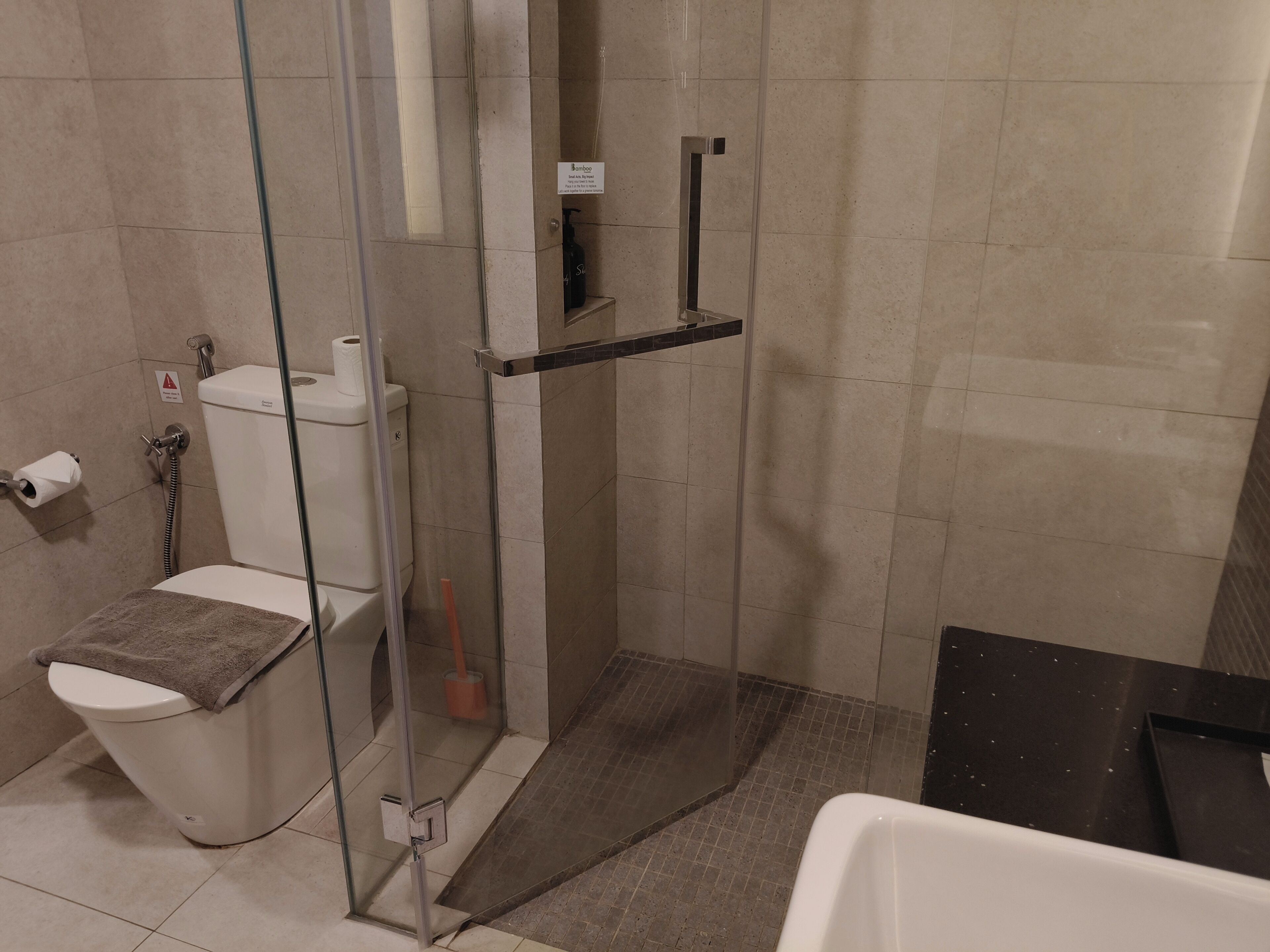 Een badkamer met een douchecabine van glas, een toilet en een bad.