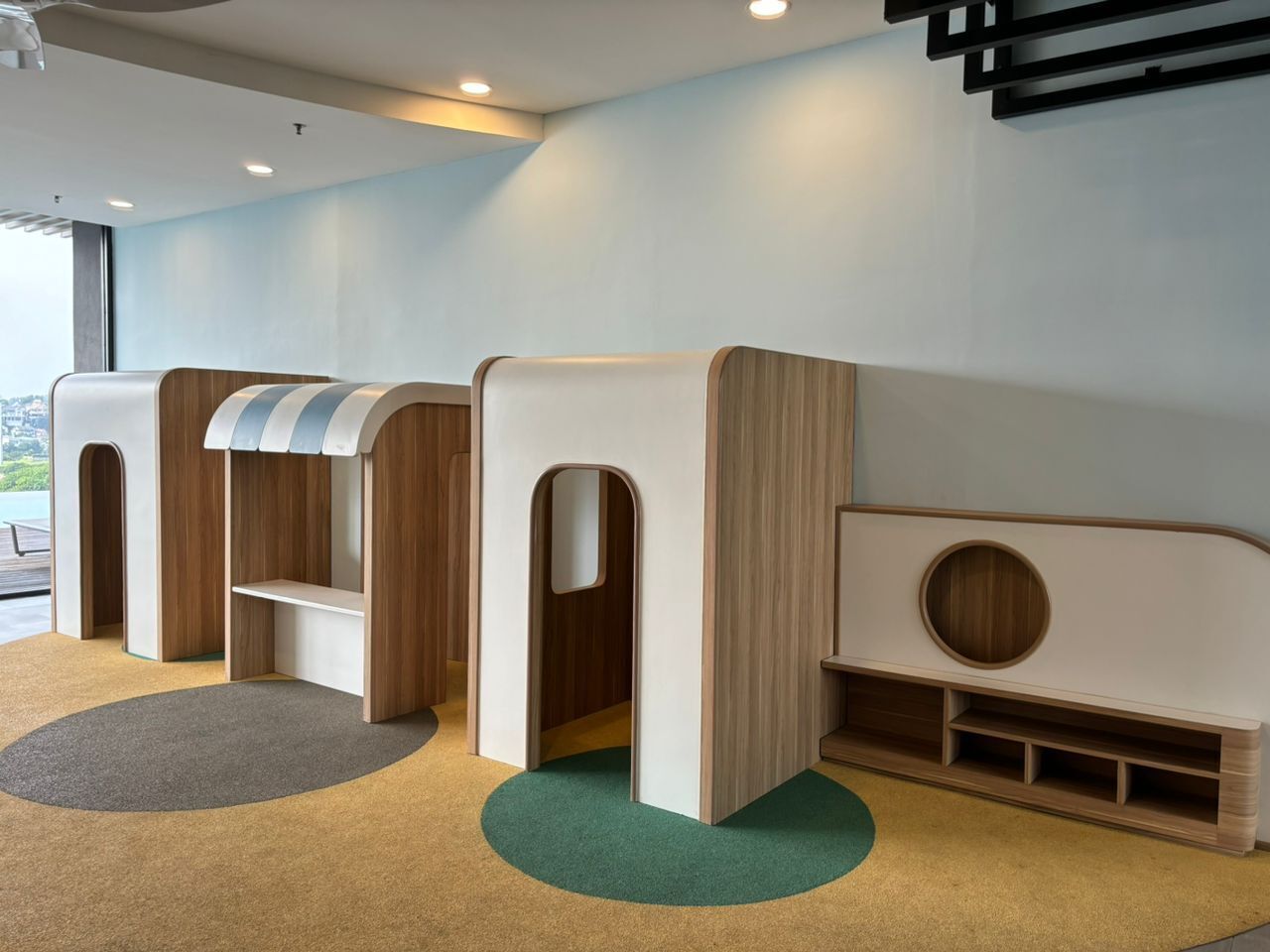 Zona infantil con juegos blandos y vistas al exterior.