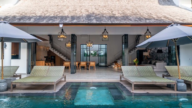 A modern pool area with lounge chairs, a staircase, and a dining area. - Villa Nusantara 5 by Alfred in Bali - Promo Luxury 4BD Pool Villa Pererenan Beach Caggu (Canggu)