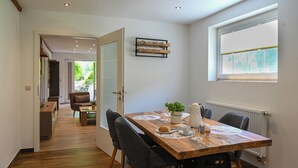 A dining area with a wooden table, chairs, and a window with a view. - Romantic mill arbor "At the foot of the Staffelberg" (Bad Staffelstein)