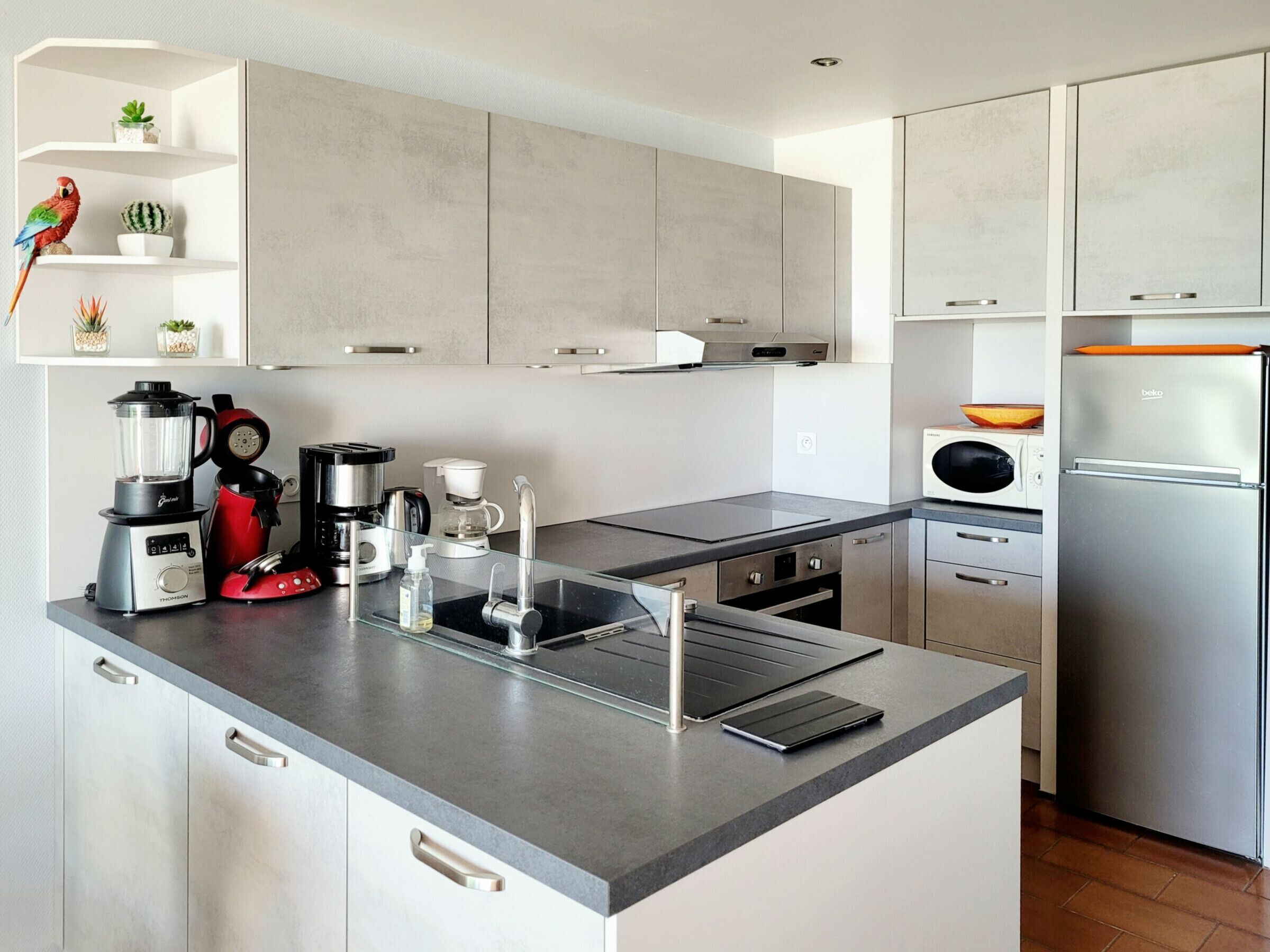A modern kitchen with a central island, stainless steel appliances, and a minimalist design.