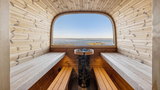 A wooden cabin with a large arched window offering a view of the water. - Nice home in Wunstorf/Steinhuder (Wunstorf/Steinhuder)