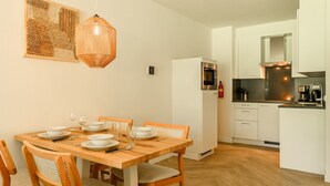 A compact kitchen with a refrigerator, oven, and coffee maker. - 4-person apartment with wellness (Hageweg 'T Centrum)