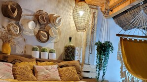A cozy room with a wooden floor, a bed with yellow bedding, and a hanging chair. - HOUSE "L'OLIVETTE" jacuzzi, heated pool, billiards, table soccer, 7KM from Nîmes  (LANGLADE)