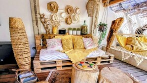A rustic room with a wooden bed, a hammock, and a round wooden table. - HOUSE "L'OLIVETTE" jacuzzi, heated pool, billiards, table soccer, 7KM from Nîmes  (LANGLADE)