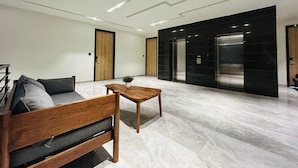 A modern interior with a sofa, coffee table, and a potted plant.