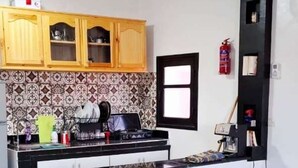 Une cuisine moderne avec des meubles en bois, un plan de travail noir et un pare-feu en carreaux.