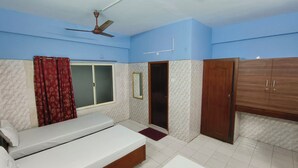 A bedroom with a bed, a wardrobe, a door, and a window. - hotel safra (Chennai)