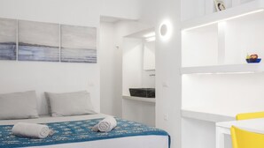 Un dormitorio moderno con cama, escritorio y silla.