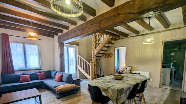 A cozy living area with a sofa, a dining table, and a staircase. - Berry cottage: covered terrace, ping-pong, near Beauval Zoo and Valençay Castle (Vicq-sur-Nahon)