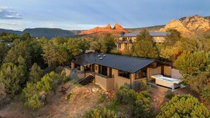 Une maison moderne dotée d’une grande terrasse, d’un jacuzzi et offrant une vue sur les montagnes.