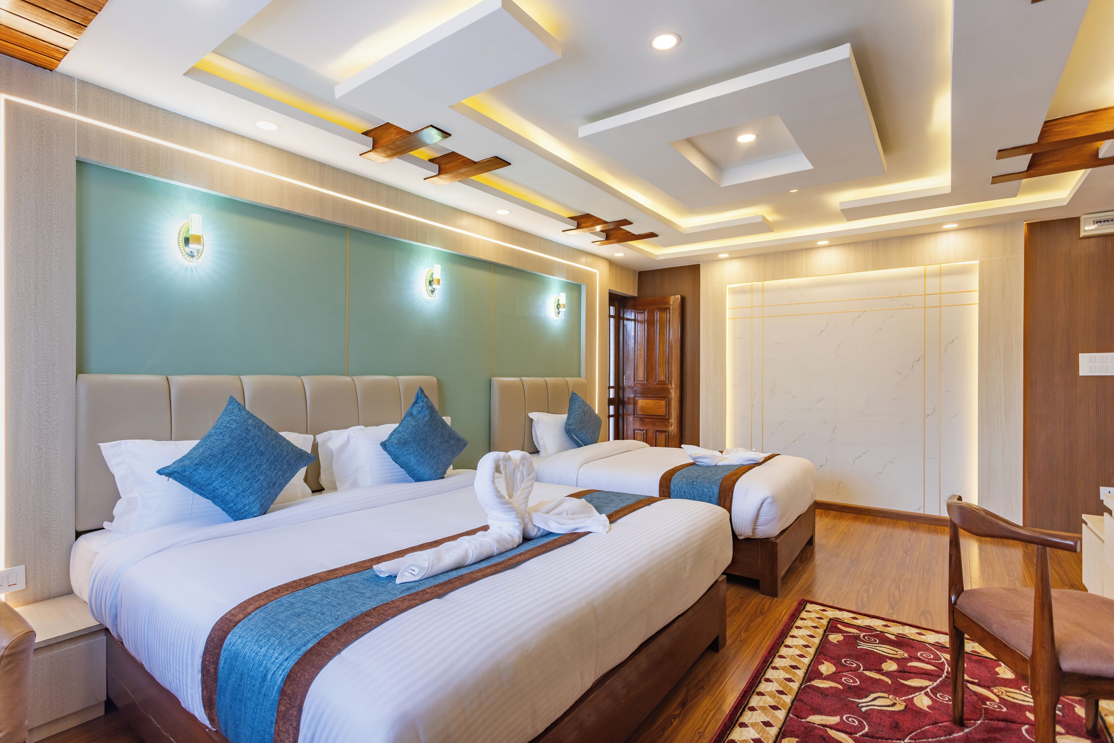 Quarto de hotel com duas camas, teto de madeira e tapete vermelho estampado.
