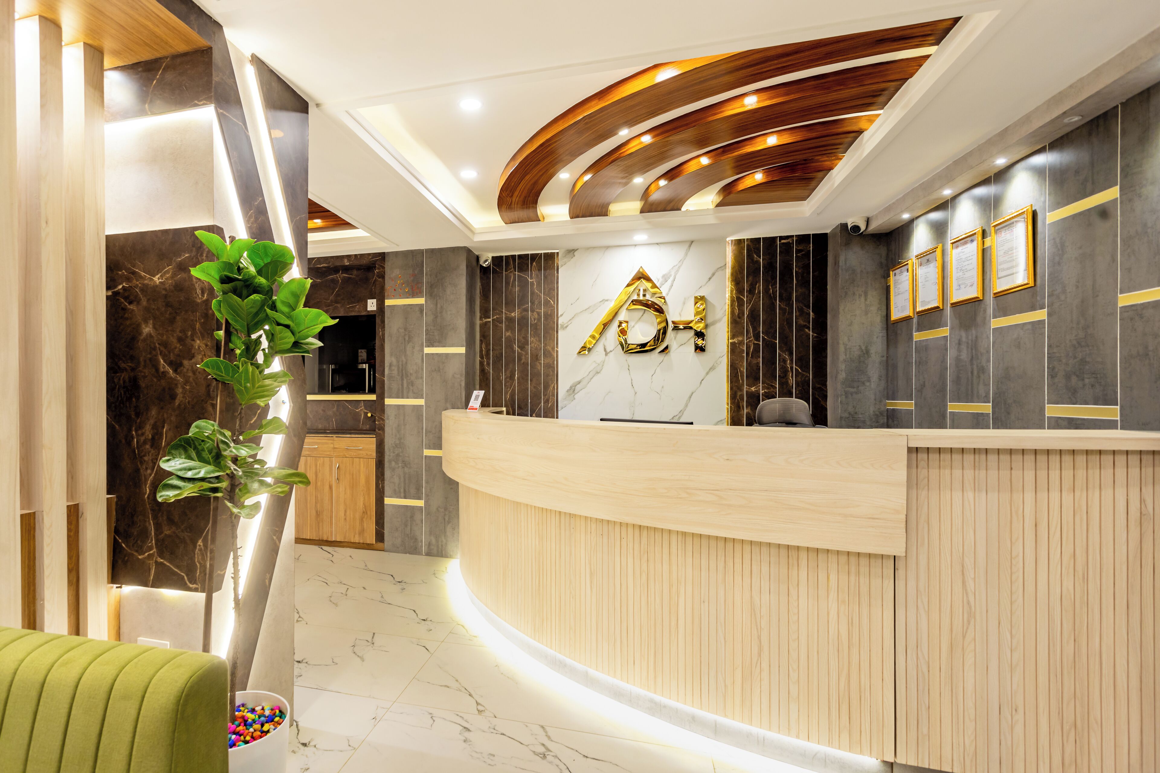 A modern reception area with a curved reception desk, marble flooring, and a wooden ceiling with recessed lighting.