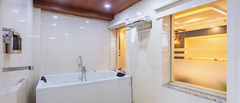 Un baño moderno con una bañera independiente, un perchero y una ventana con vistas al interior.
