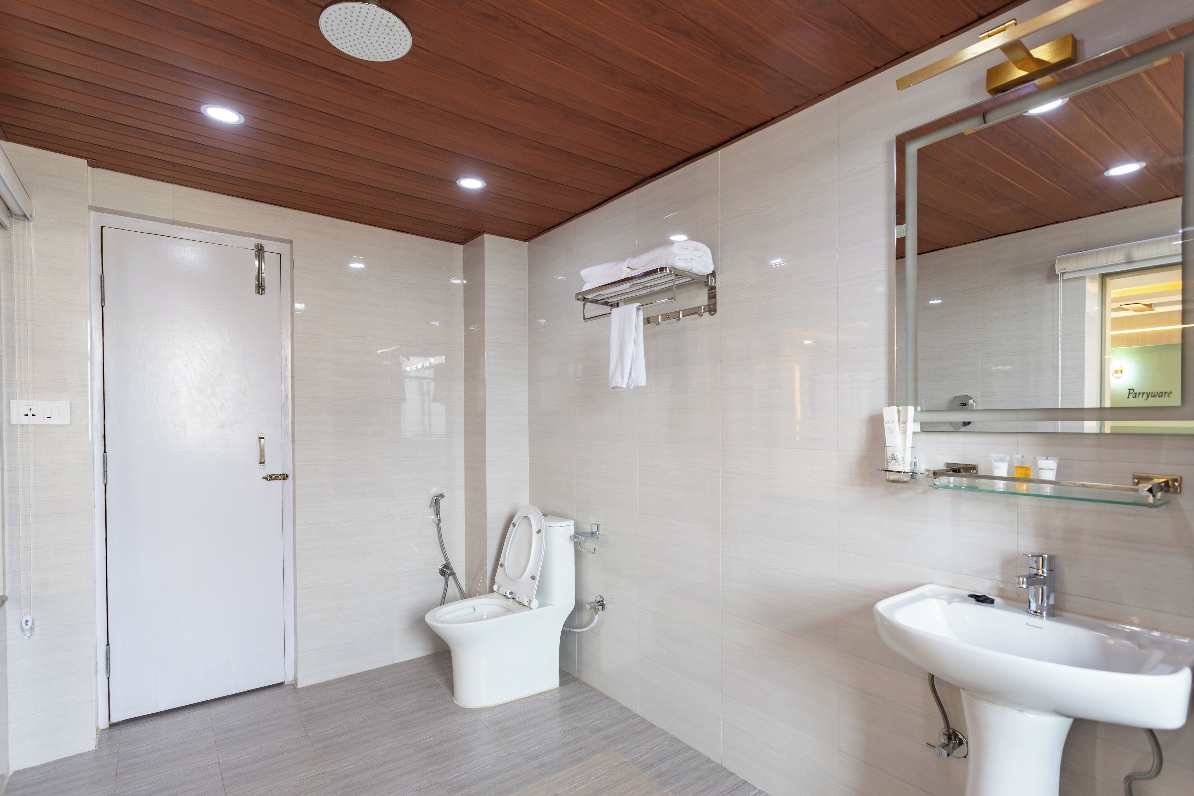 Een moderne badkamer met toilet, wastafel en spiegel.