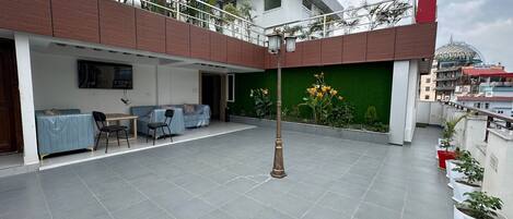 Une terrasse sur le toit, aménagée avec des sièges, un mur végétal et des plantes en pot.