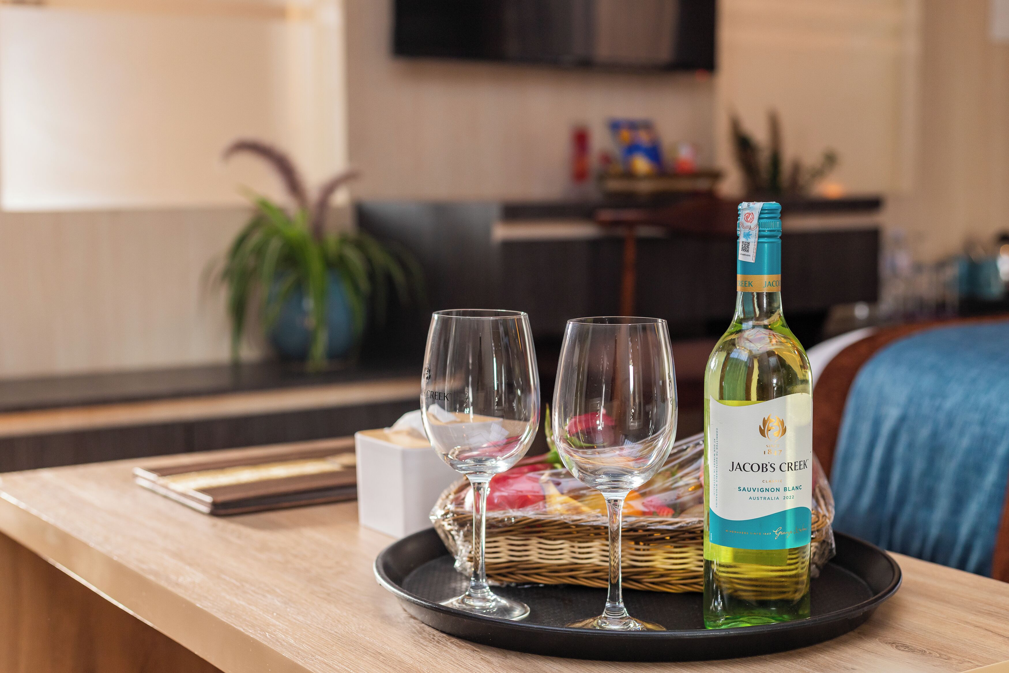 Een fles Jacob’s Creek Sauvignon Blanc op een dienblad met twee glazen.