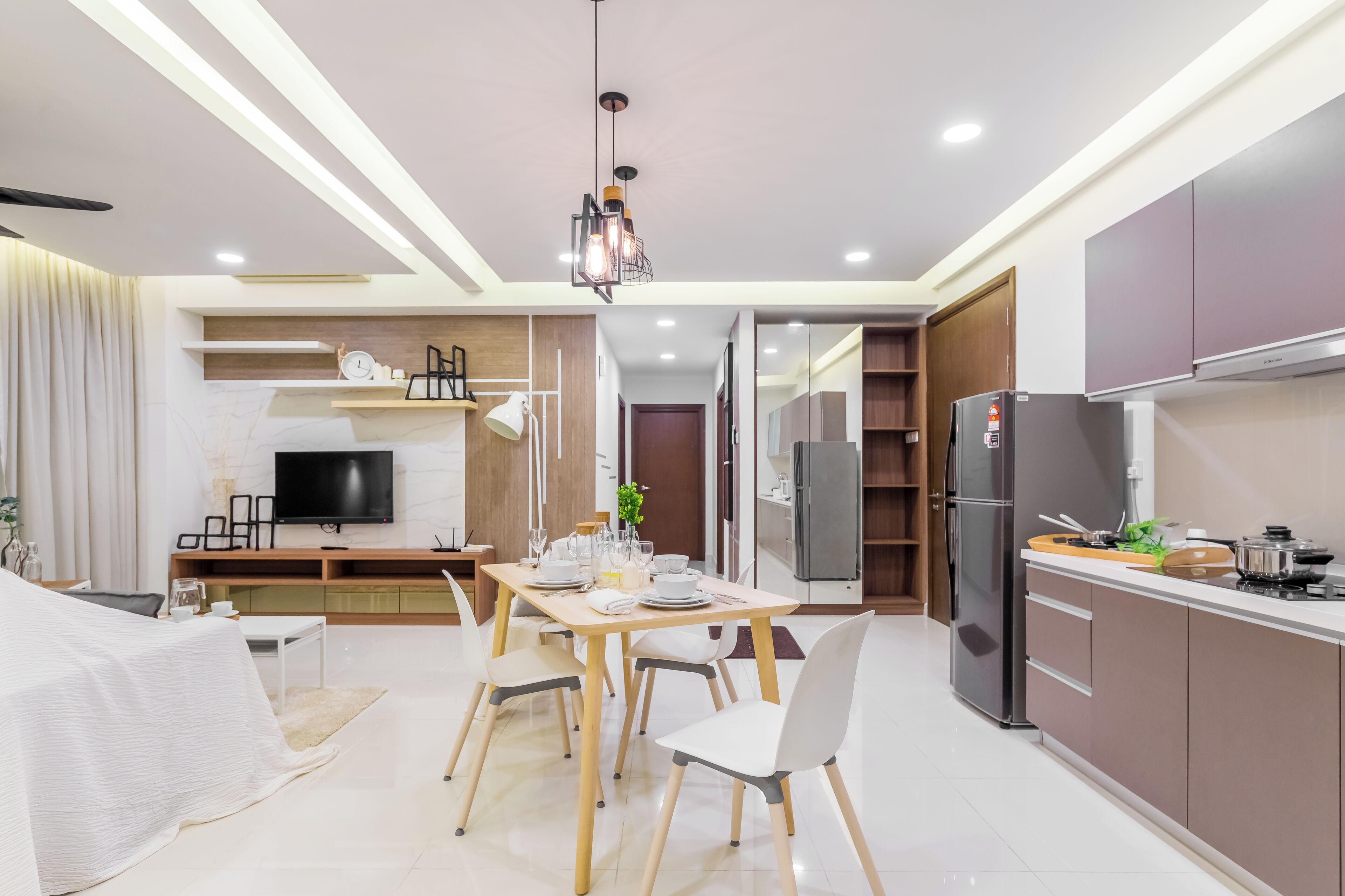 Una cucina moderna con zona pranzo, elettrodomestici integrati e televisore a schermo piatto.