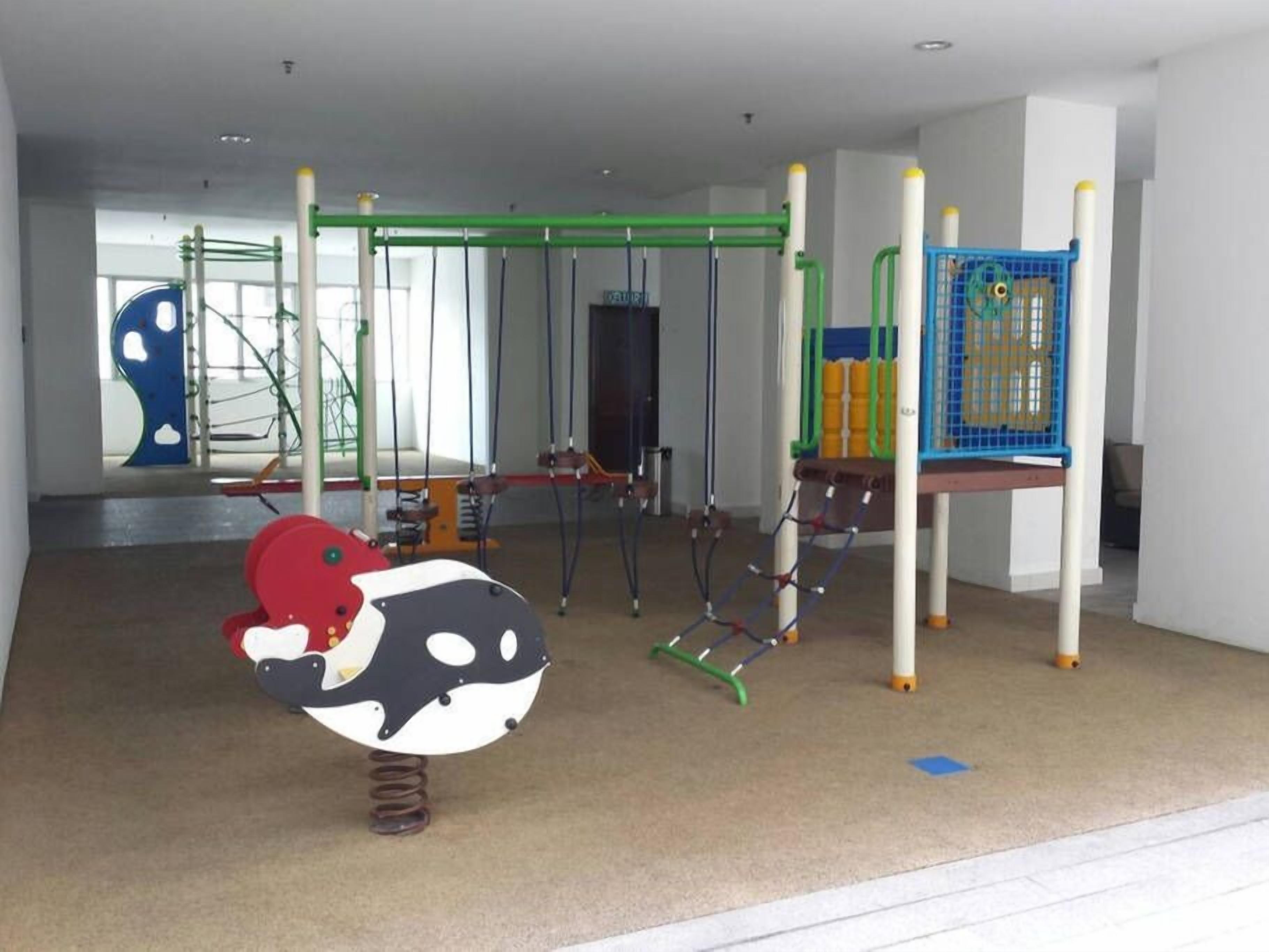 A children's play area with various climbing structures and a swing set.