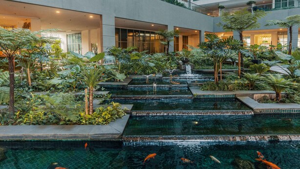 A multi-level indoor garden with tiered water features and lush greenery. - NaiBnB @ Regalia Residence (Kuala Lumpur)