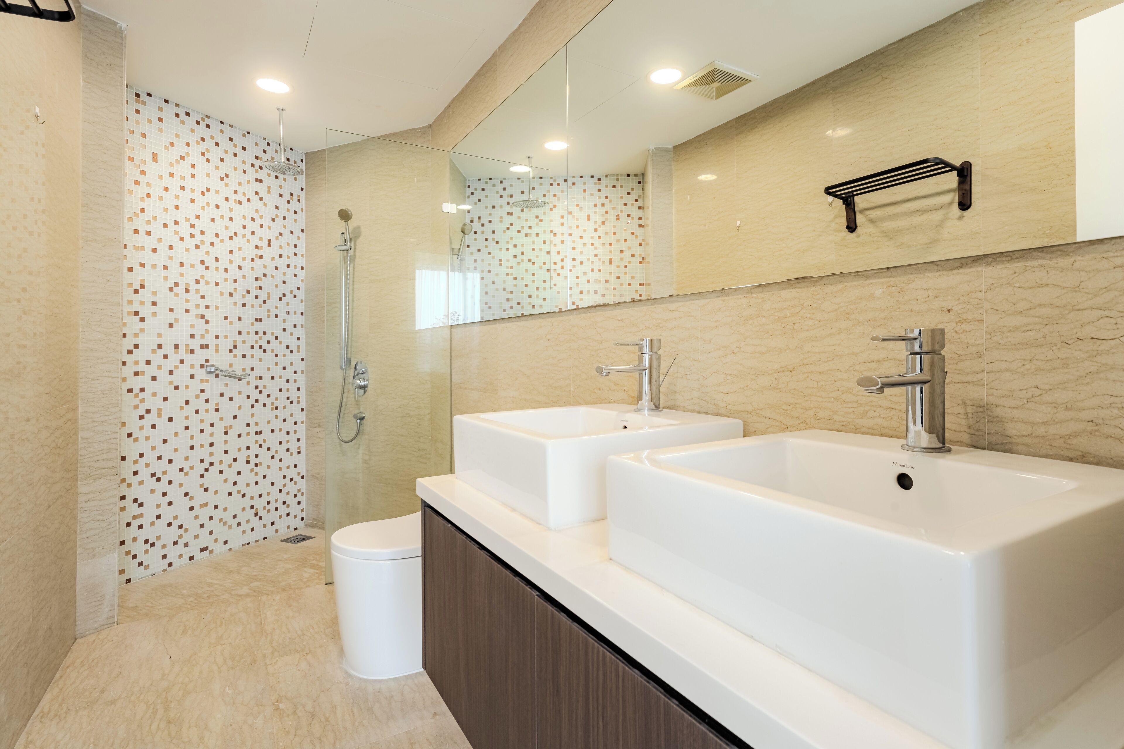 Un baño moderno con dos lavamanos, ducha e inodoro.