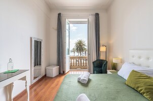Una habitación de hotel con una cama, un escritorio, una silla y vista a la playa.