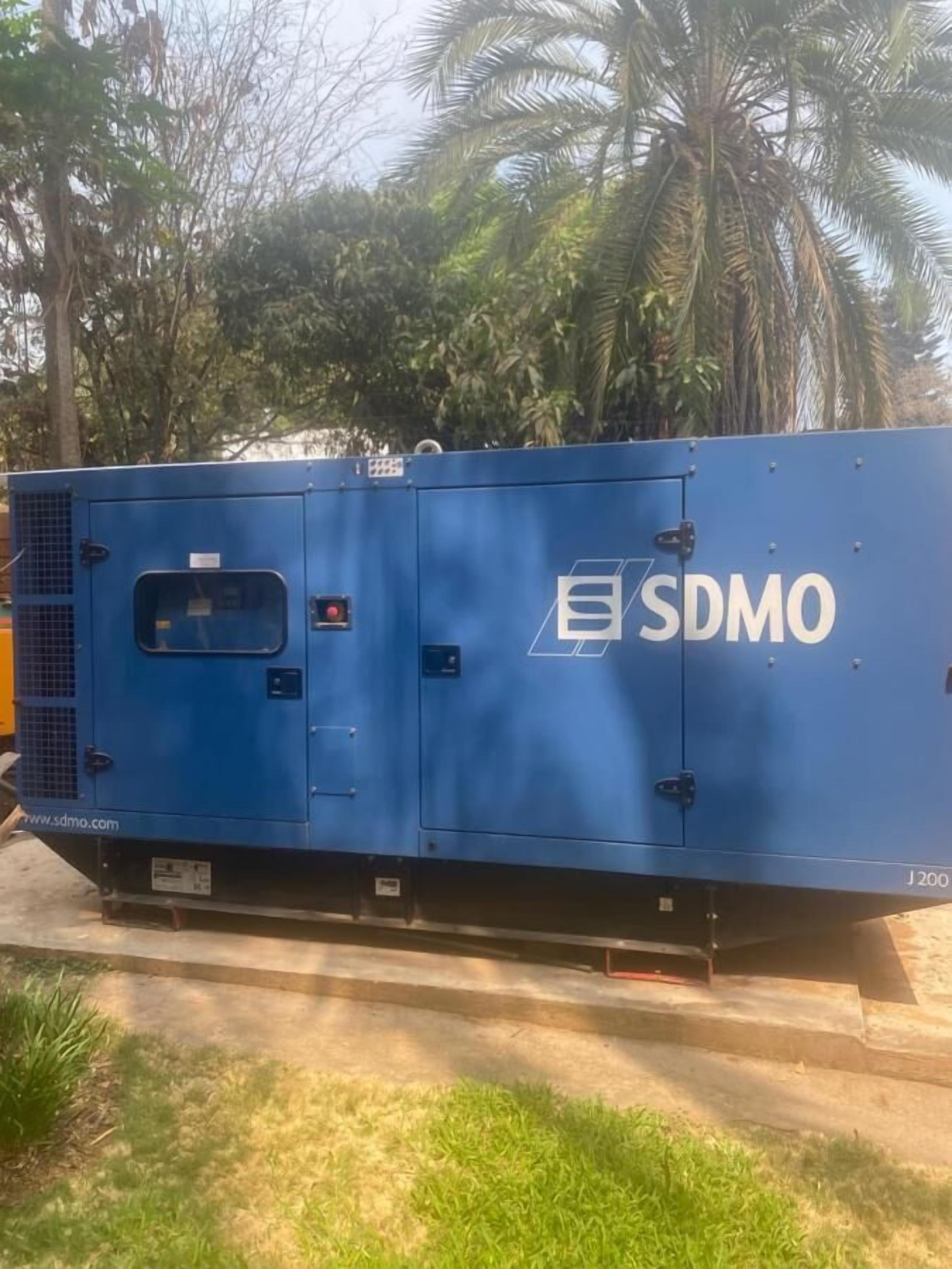 A blue industrial machine with the logo 'SDMO' and model number 'J200'.