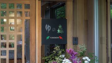 A wooden entrance with a black sign featuring a bird and a plant.