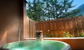 A hot tub with a wooden fence and trees in the background. - Okunikko Yumoto Onsen Yunomori (Nikko)