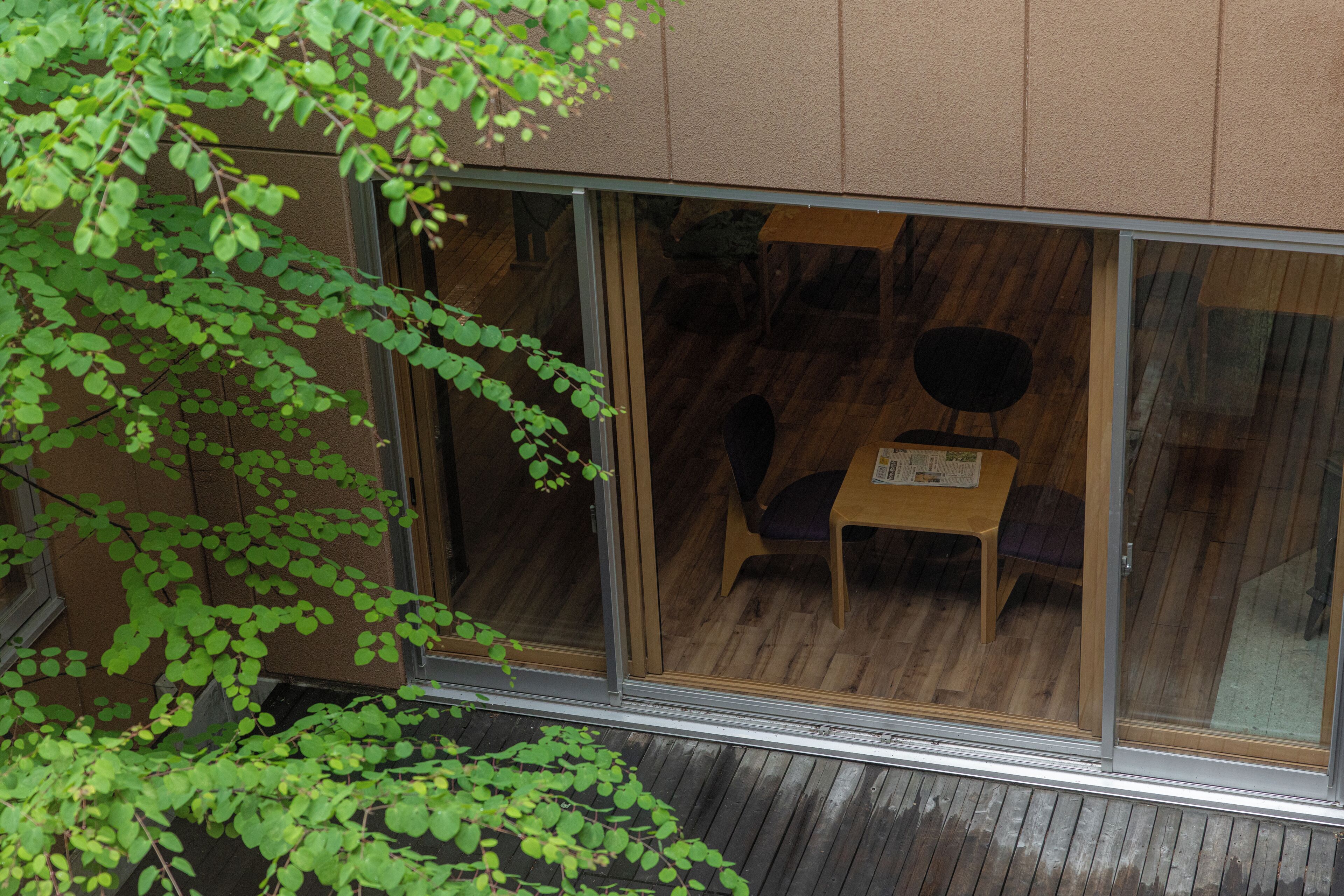 A room with a wooden floor, a small table, and a chair.