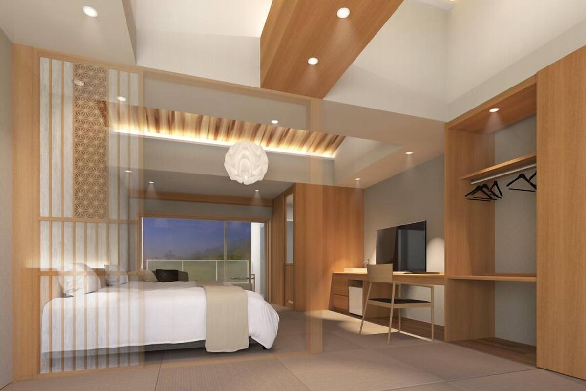 A modern bedroom with a bed, desk, TV, and wardrobe.