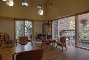 A spacious room with large windows, a fireplace, and modern furniture. - Okunikko Yumoto Onsen Yunomori (Nikko)