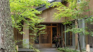 A wooden building with a traditional entrance, a potted plant, and a small garden area. - Okunikko Yumoto Onsen Yunomori (Nikko)