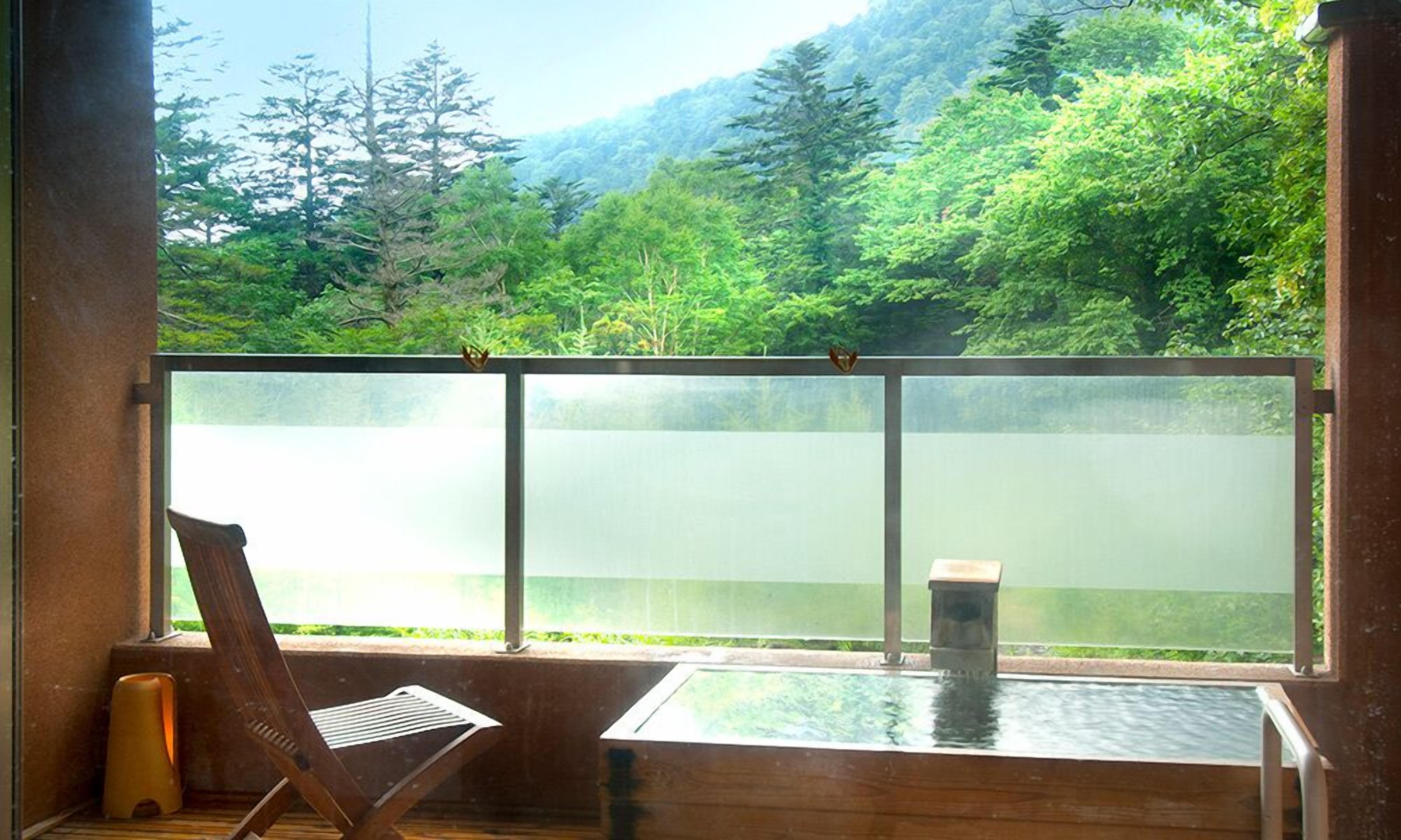 Una habitación con un ventanal grande con vistas a un área boscosa.