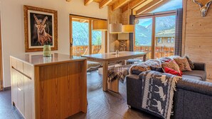Un intérieur en bois comprenant une table à manger, un canapé et un tableau représentant un animal.