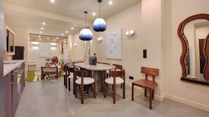 Un comedor moderno con una mesa redonda, sillas de madera e iluminación colgante.