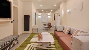 Una sala de estar moderna con un sofá, una mesa de centro y un televisor de pantalla plana montado en la pared.