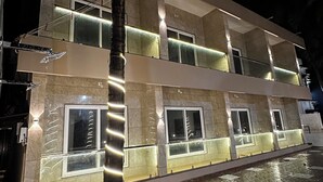 A multi-story building with illuminated windows and a paved courtyard. - Sun & Sand Luxury Stays Sea View (Bhatkal)