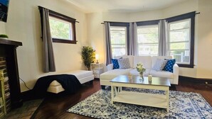 A living room with a sofa, a coffee table, and a rug. - 2024 Remodeled 2bedroom in West CLE (Cleveland)