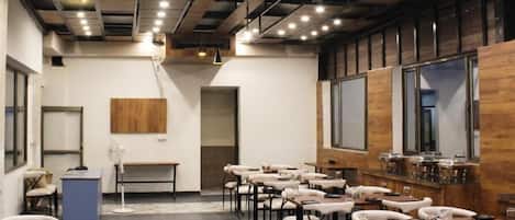 A conference room with tables and chairs, a whiteboard, and a wooden accent wall.