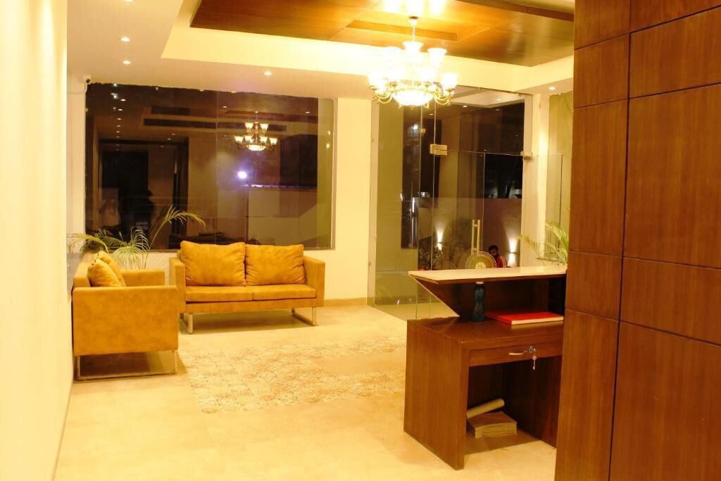 A modern living room with a sofa, a wooden desk, and a glass partition.