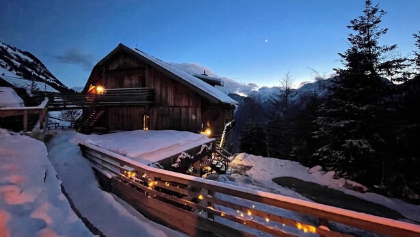 A wooden cabin with a snow-covered roof, surrounded by snow and a mountain backdrop. - Spacious apartment with beautiful views near slopes (Villard-Reculas)